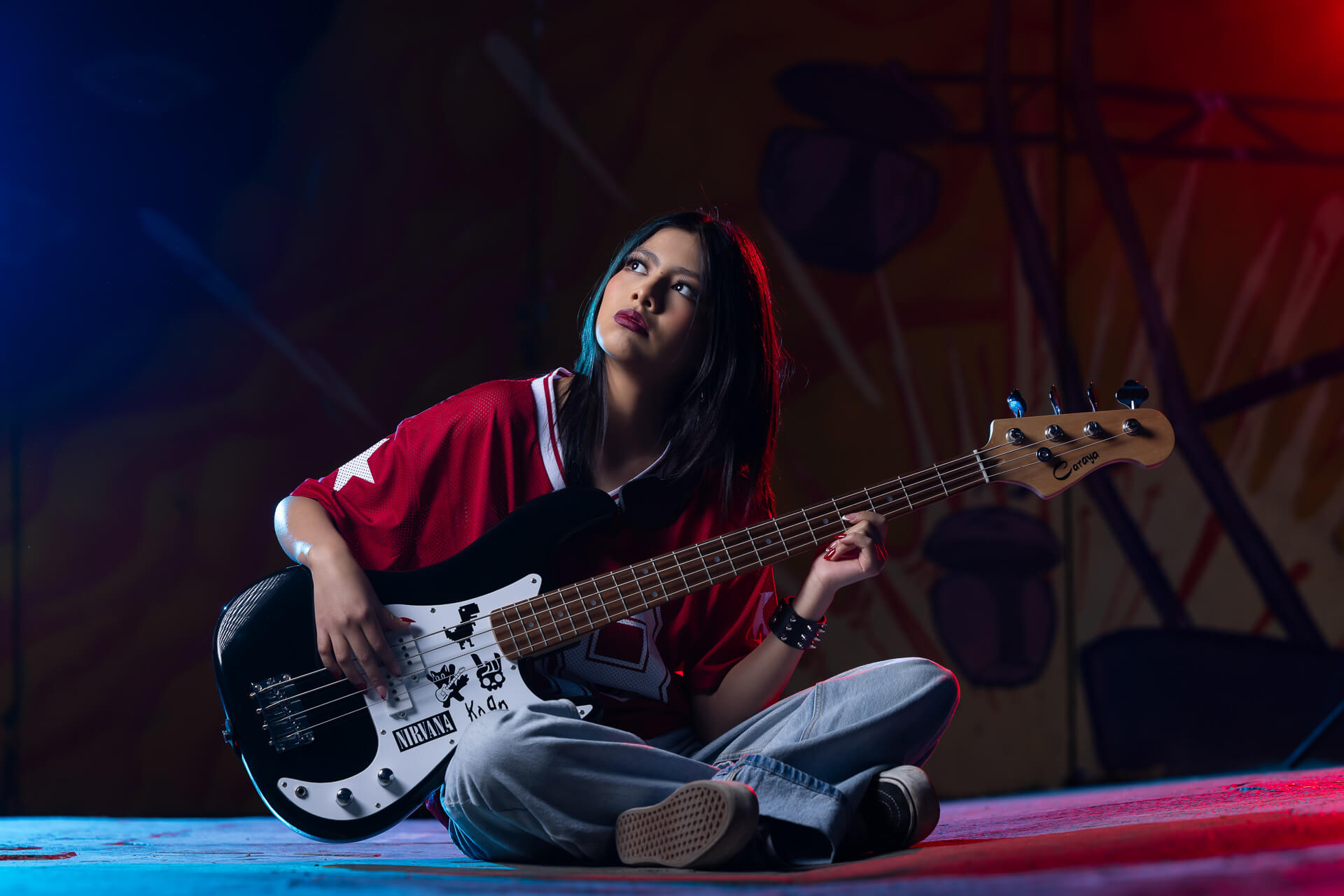 Mi hija en su sesión pre 15 años urbana posando con bajo eléctrico y camiseta roja