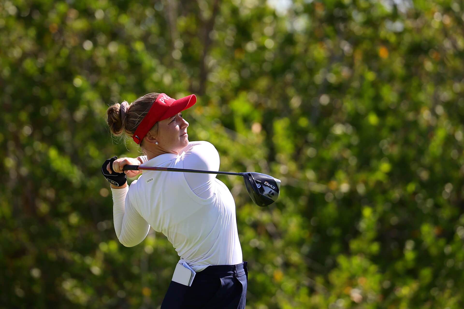 Retrato de acción de golfista profesional concentrada tras el impacto del golpe. Fotografía de Golf Profesional