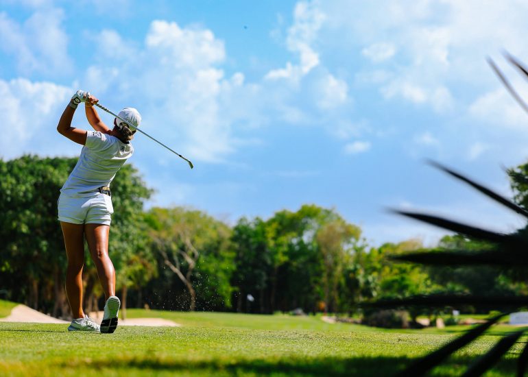 Jugadora de golf ejecutando un drive potente en el club de golf El Camaleón.