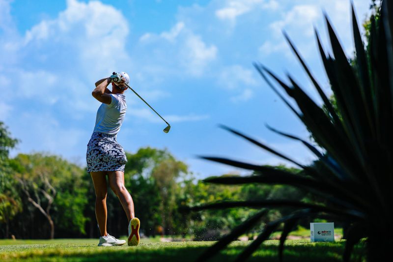 Golfista profesional terminando su swing en el torneo Riviera Maya Open.