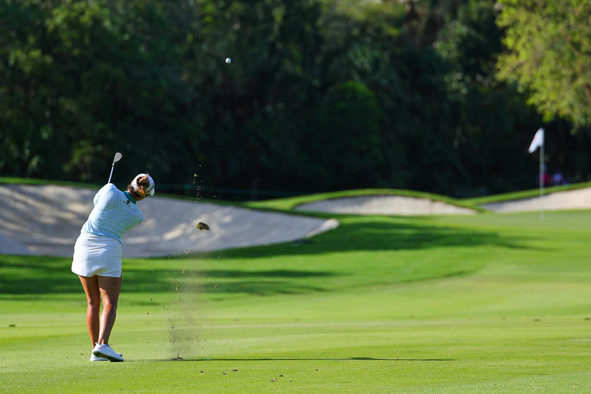 Jugadora de golf realizando un golpe de approach en el campo El Camaleón, Mayakoba.
