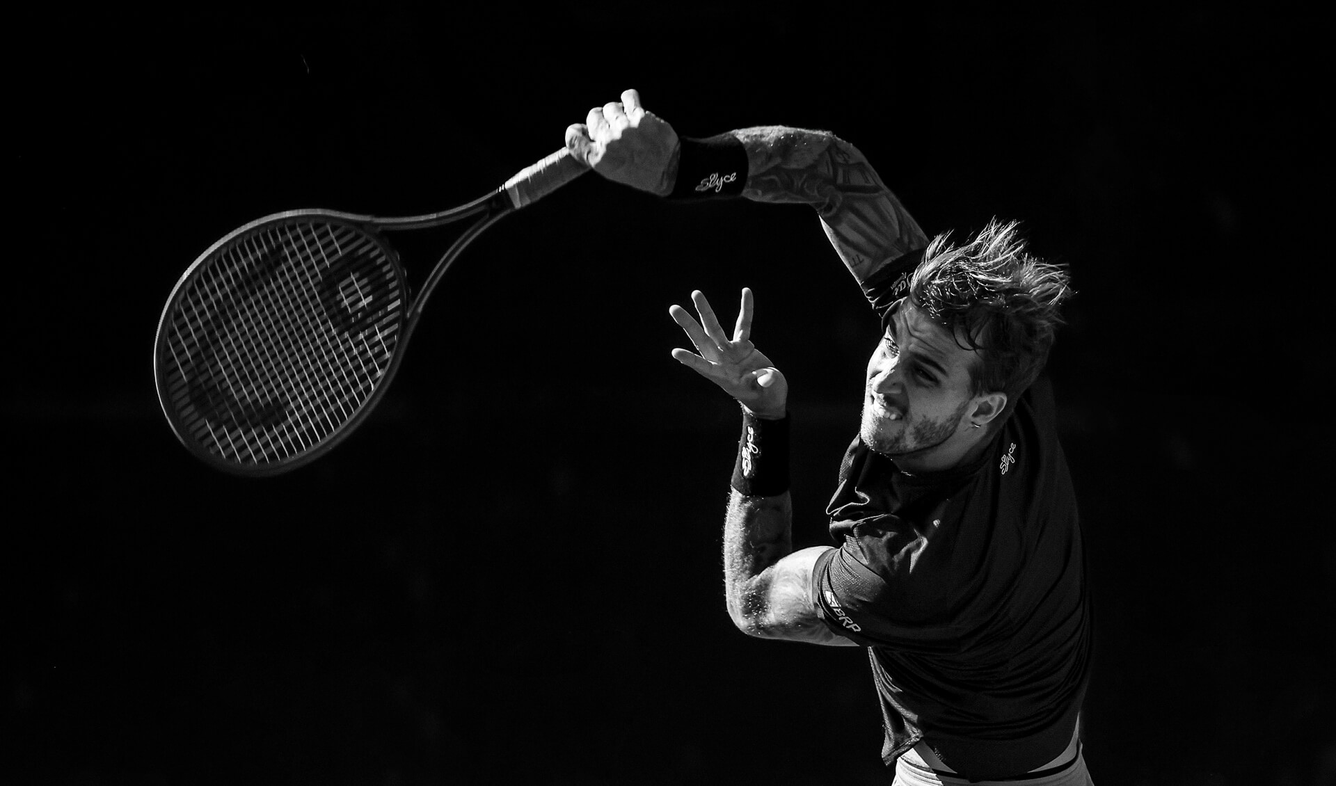 Fotografía artística en blanco y negro de revés de tenis con alto contraste.