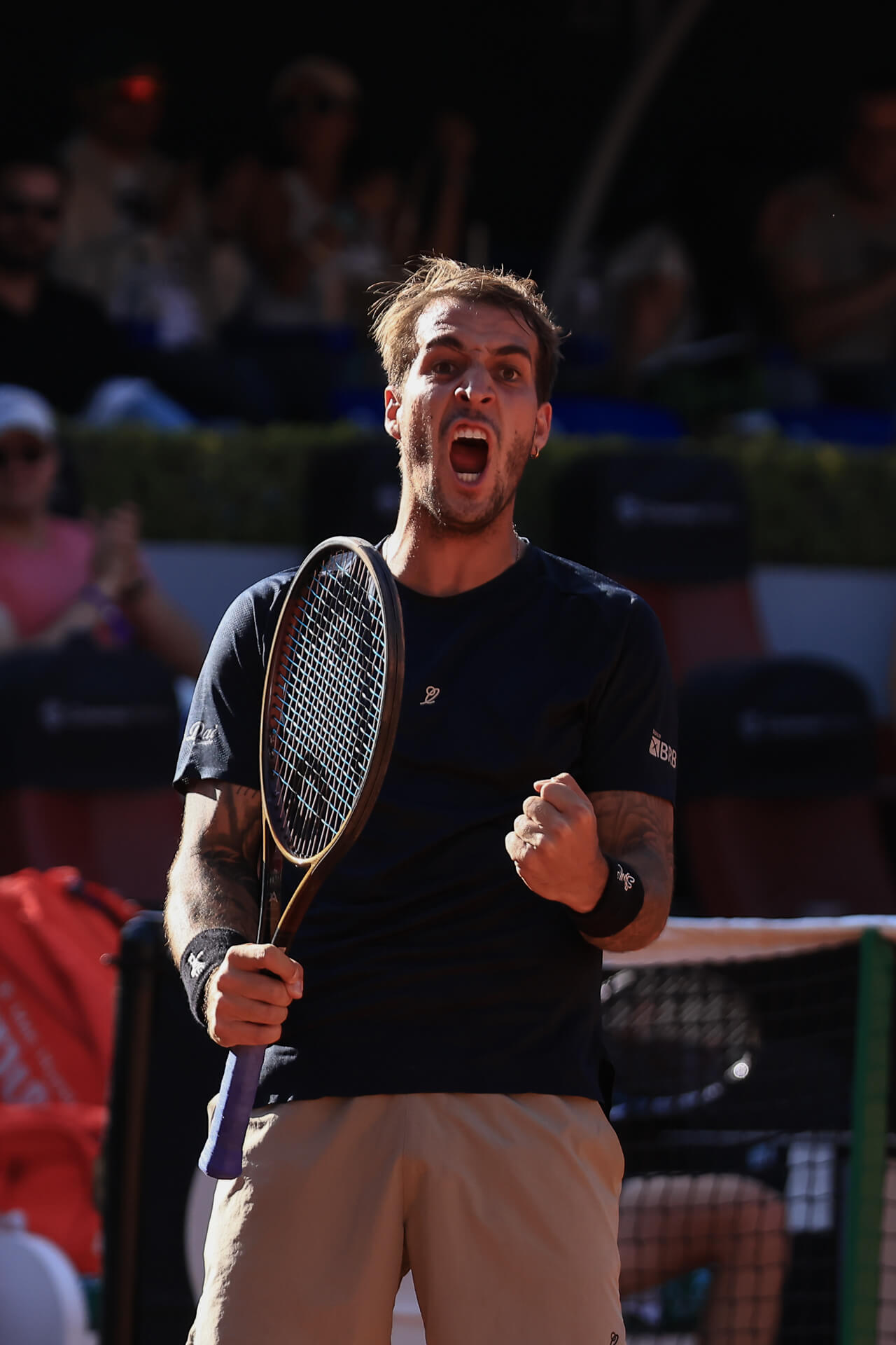 Tenista celebrando un punto importante con el puño cerrado y expresión de triunfo.