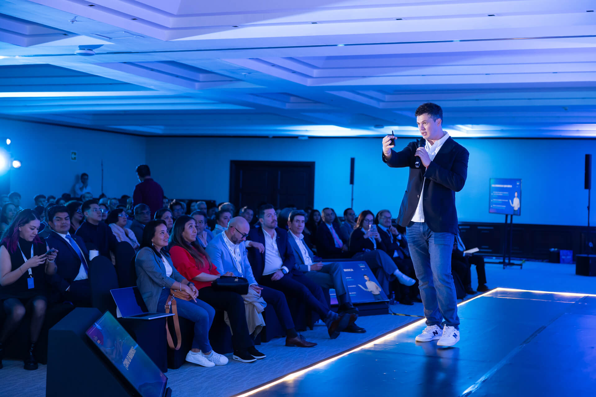 Uso de iluminación profesional en la cobertura audiovisual para eventos corporativos en escenarios amplios.