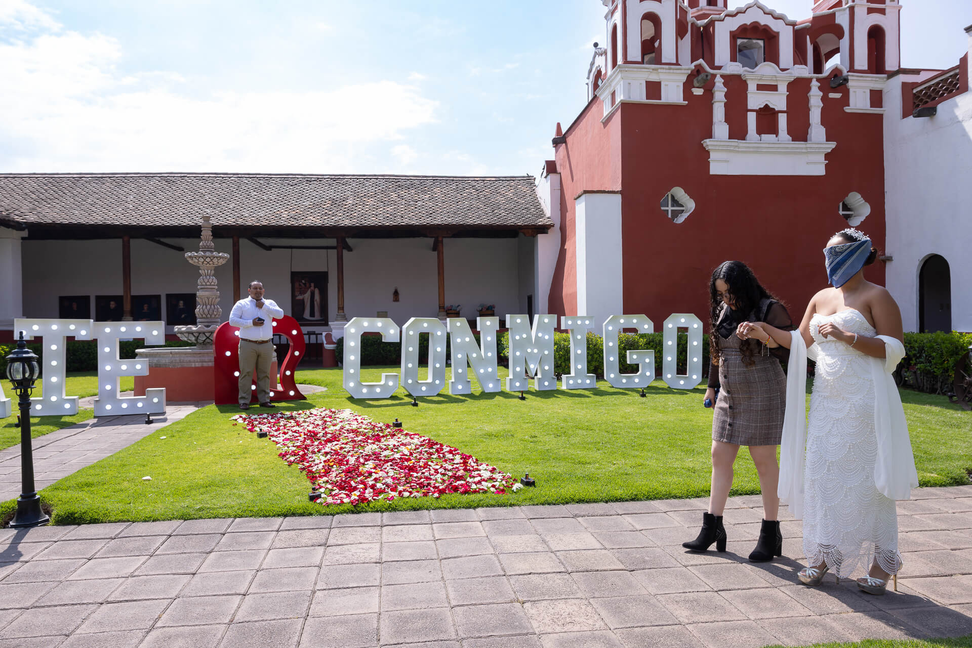 Novia vendada acercándose al set de propuesta en el jardín de Hacienda Panoaya.